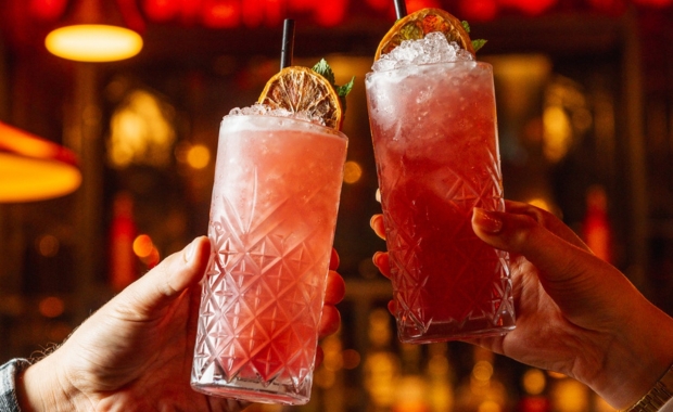 two cocktails being raised to a toast