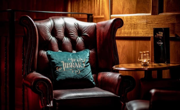 a sofa with The Library's logo printed on a pillow