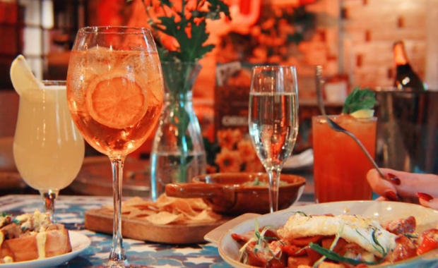 a table set with cocktails and dishes 