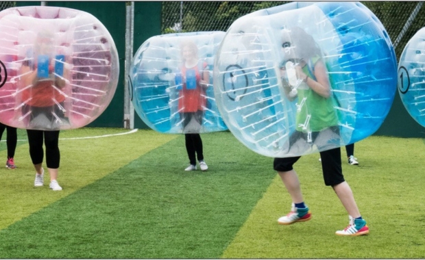 a group of women playing in zorb suites