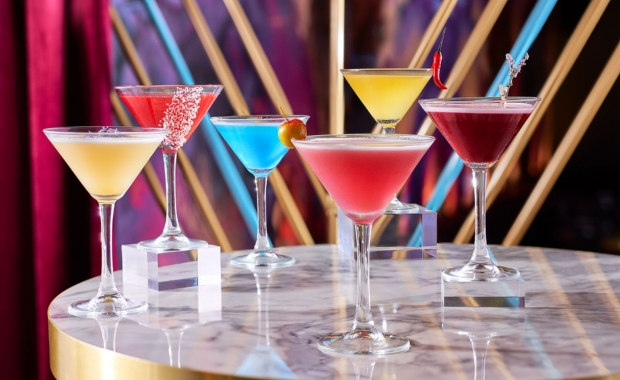 six colourful cocktail glasses on a table