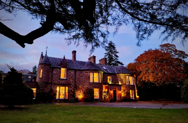 a photo of the Georgian Manor at night