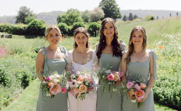 Bride and bridesmaids carrying flower bouquets 