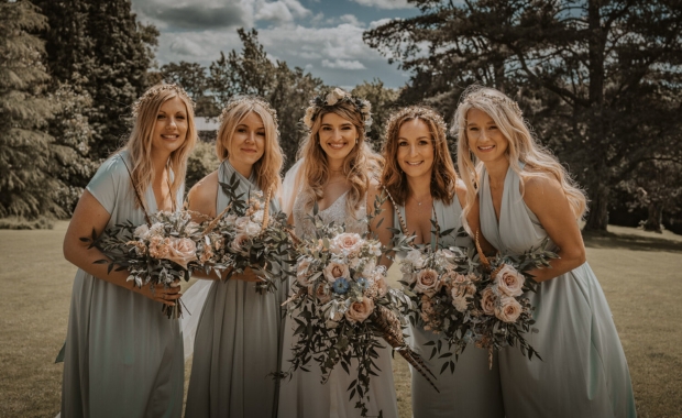 Bride and their bridesmaids holding flowers by Copper-Green 