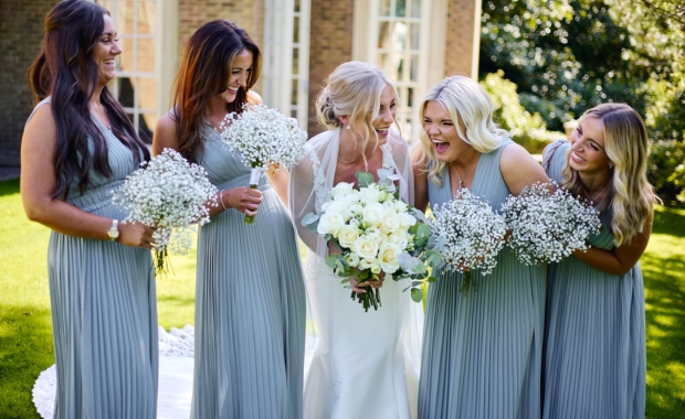 Bride and bridesmaids laughing in front of De Courceys Manor