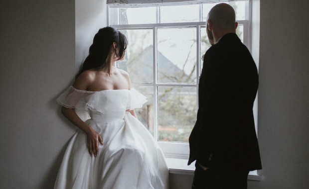 a couple wearing e&w couture looking out of a window